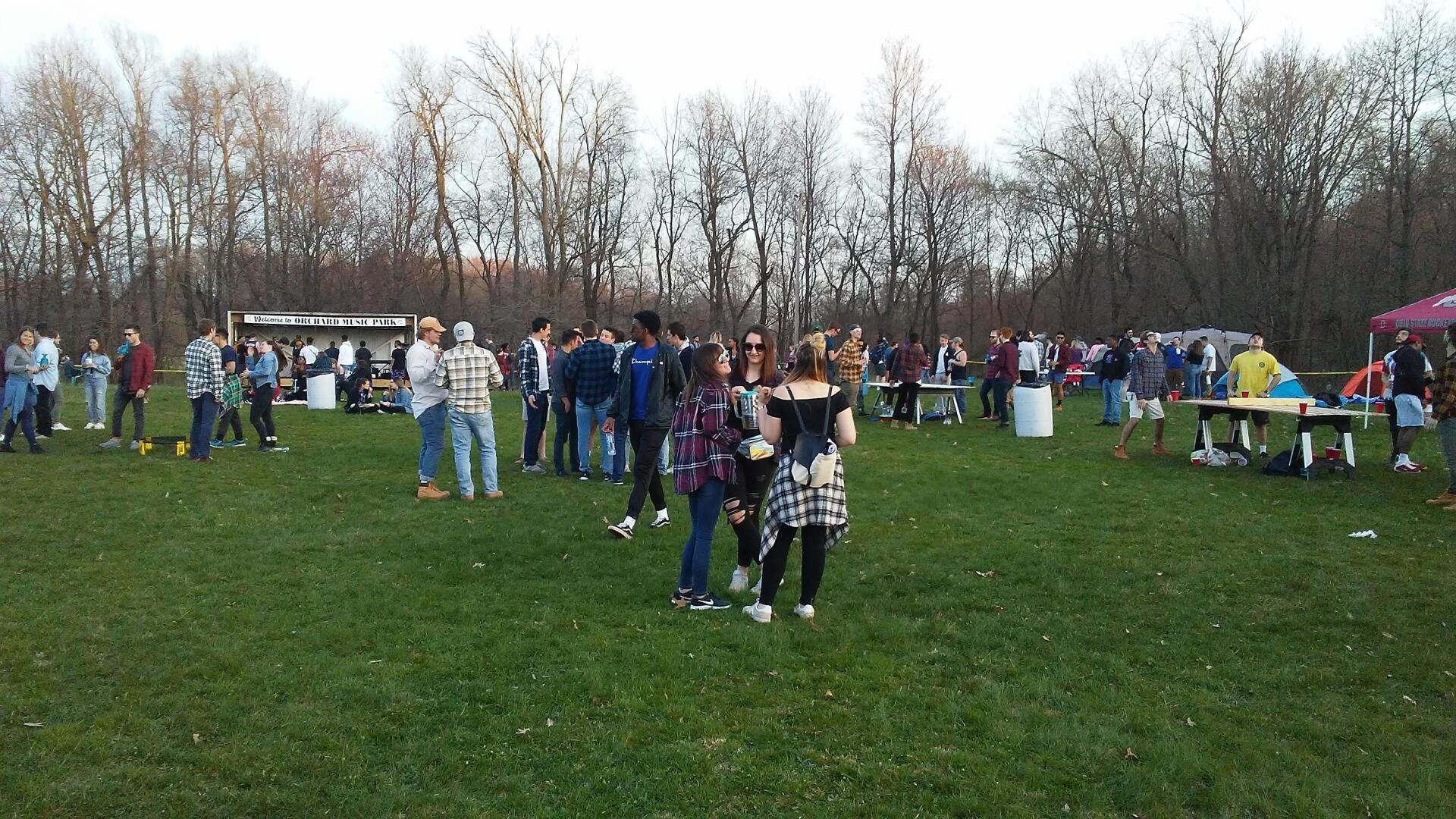 A group of people are standing in a grassy field.