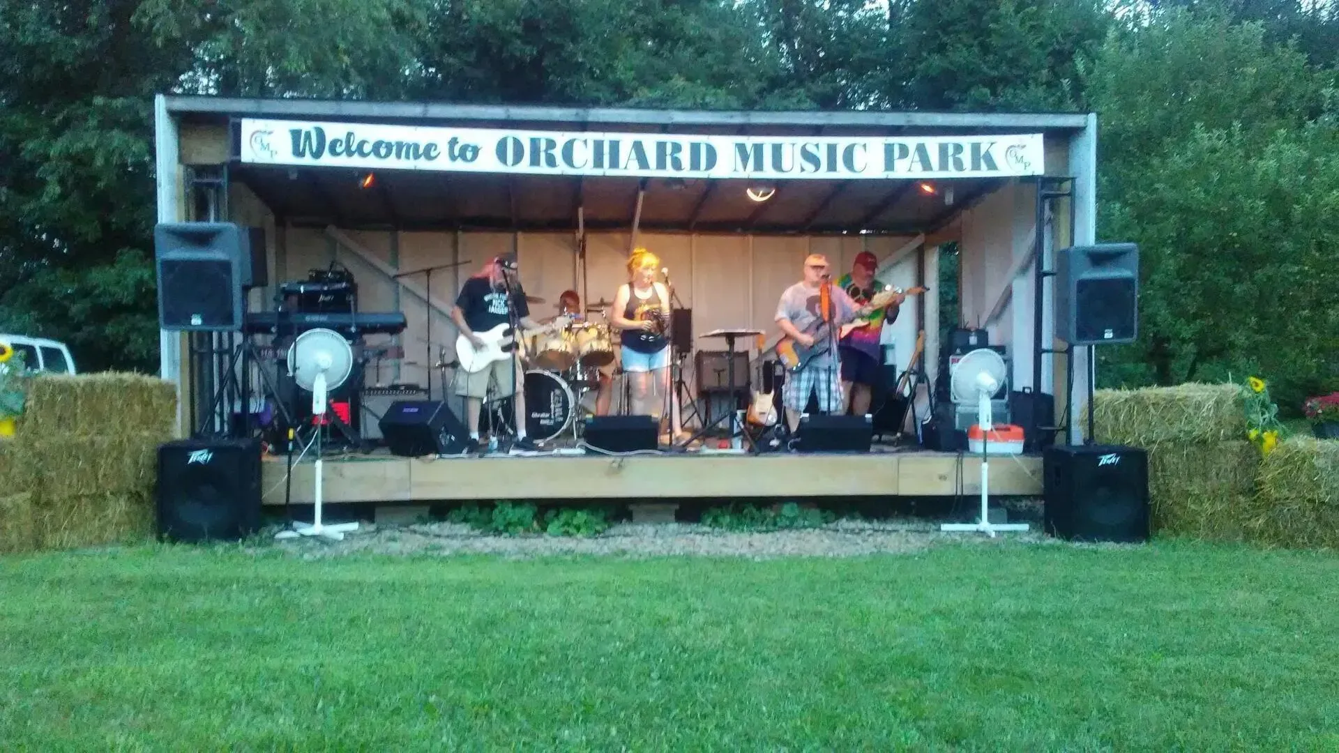 A band is playing on a stage at orchard music park