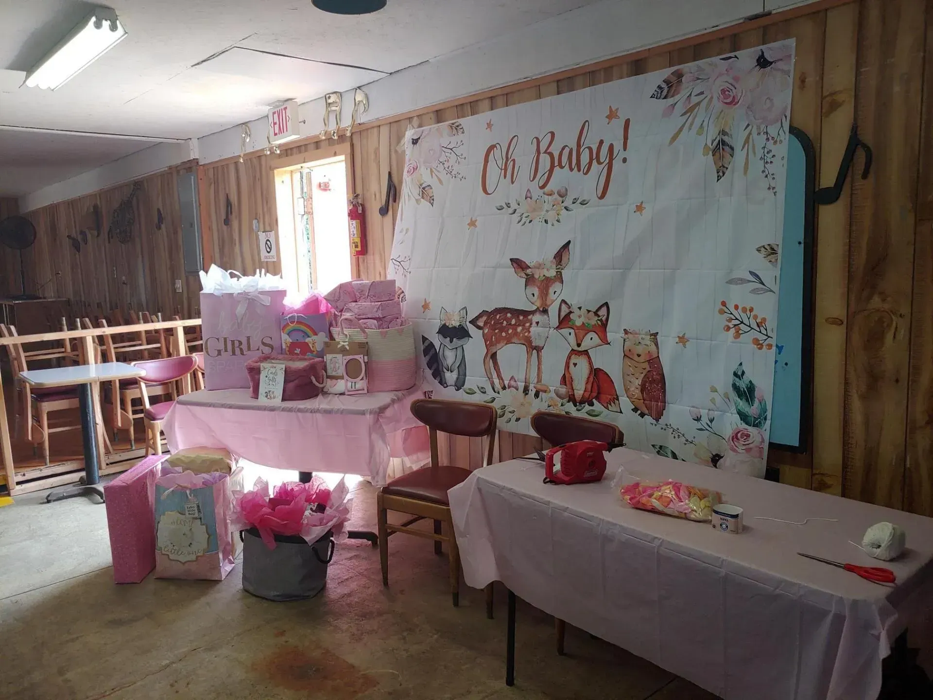 A room with tables and chairs and a sign that says `` oh baby ''.