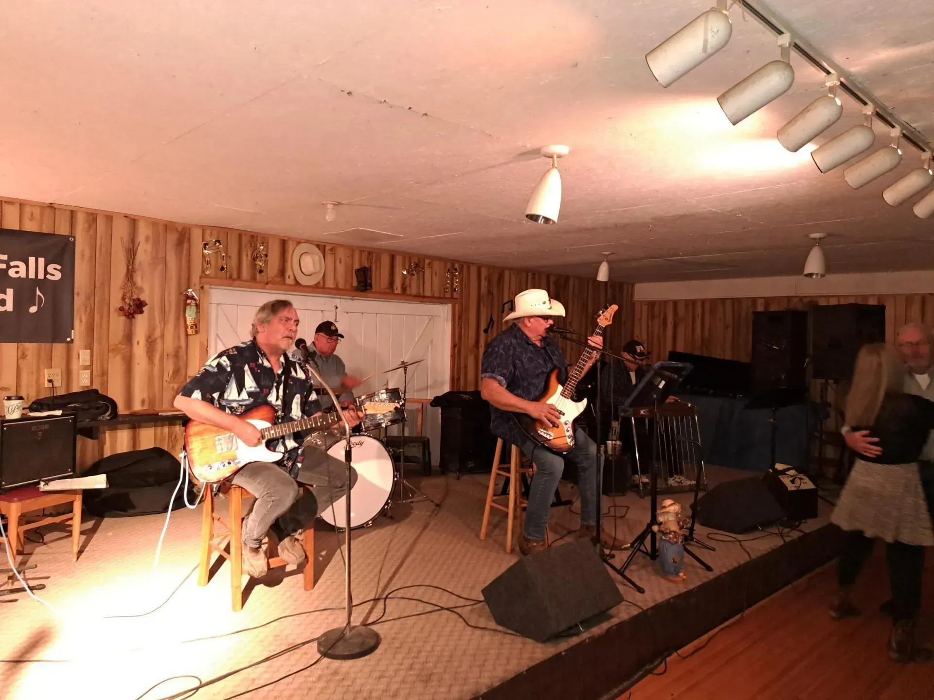 A group of men are playing guitars and singing into microphones on a stage.