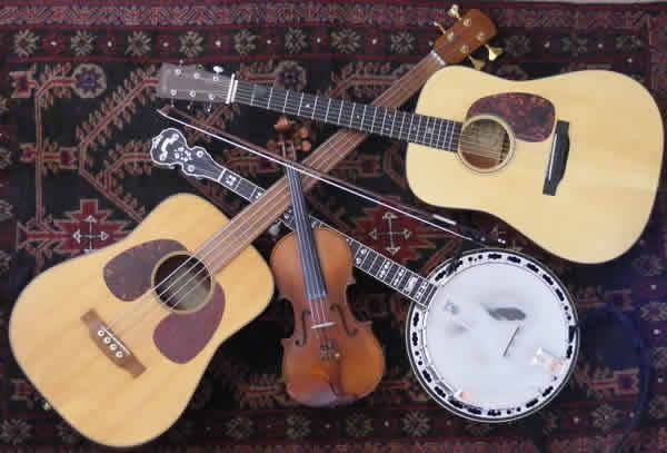 Three guitars a violin and a banjo on a rug