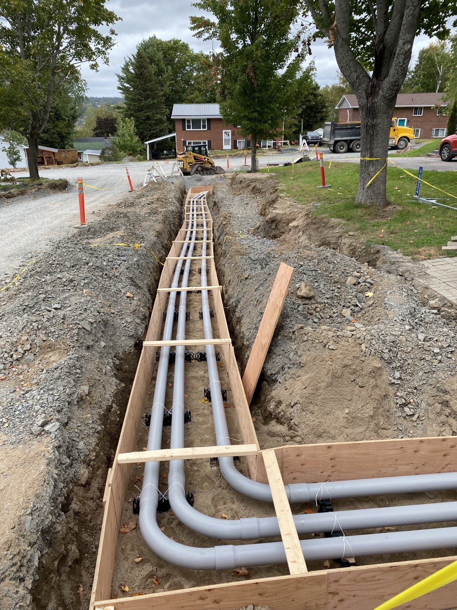 A bunch of pipes are being installed in a trench.