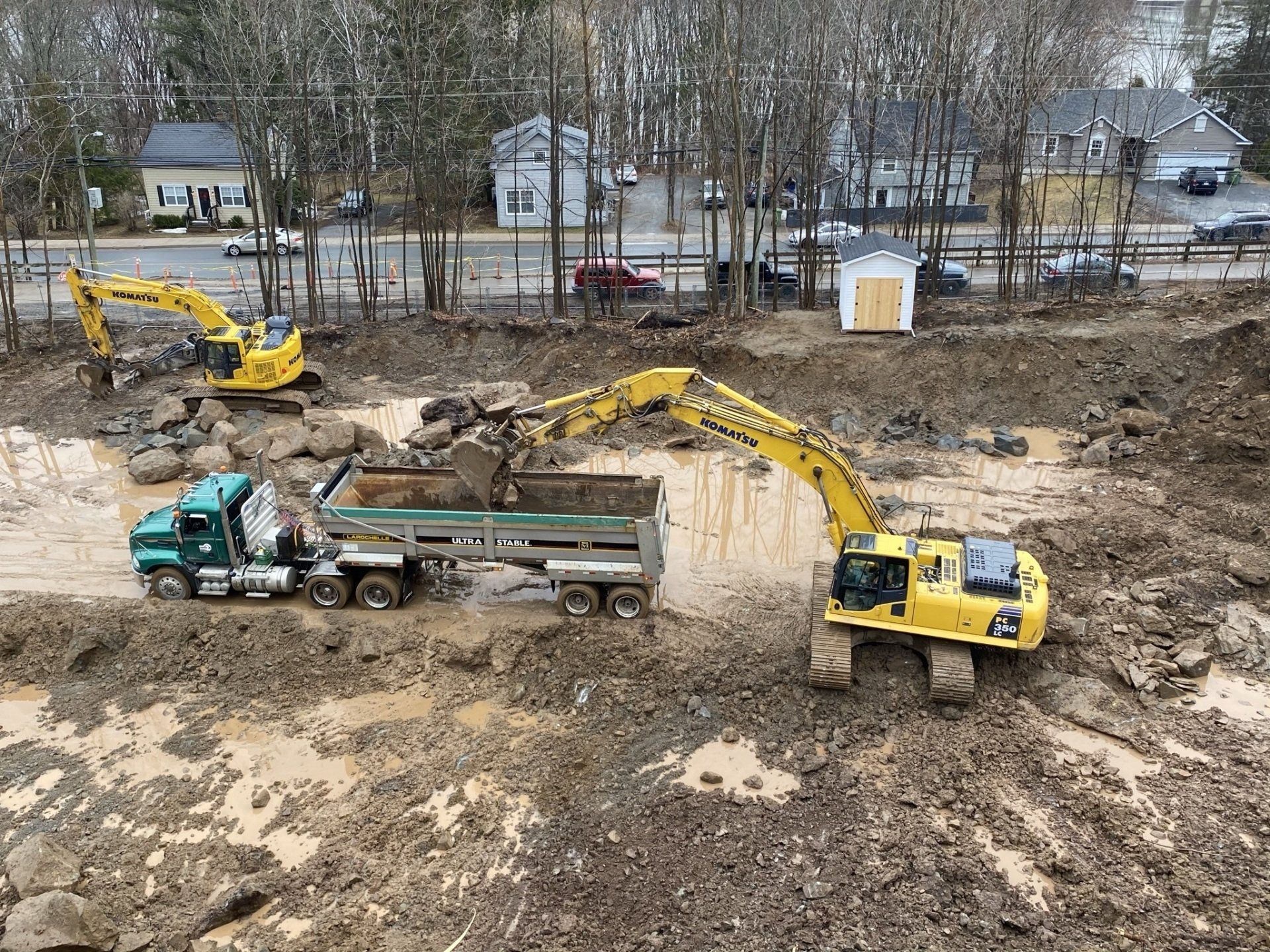 A yellow excavator is loading dirt into a dump truck.