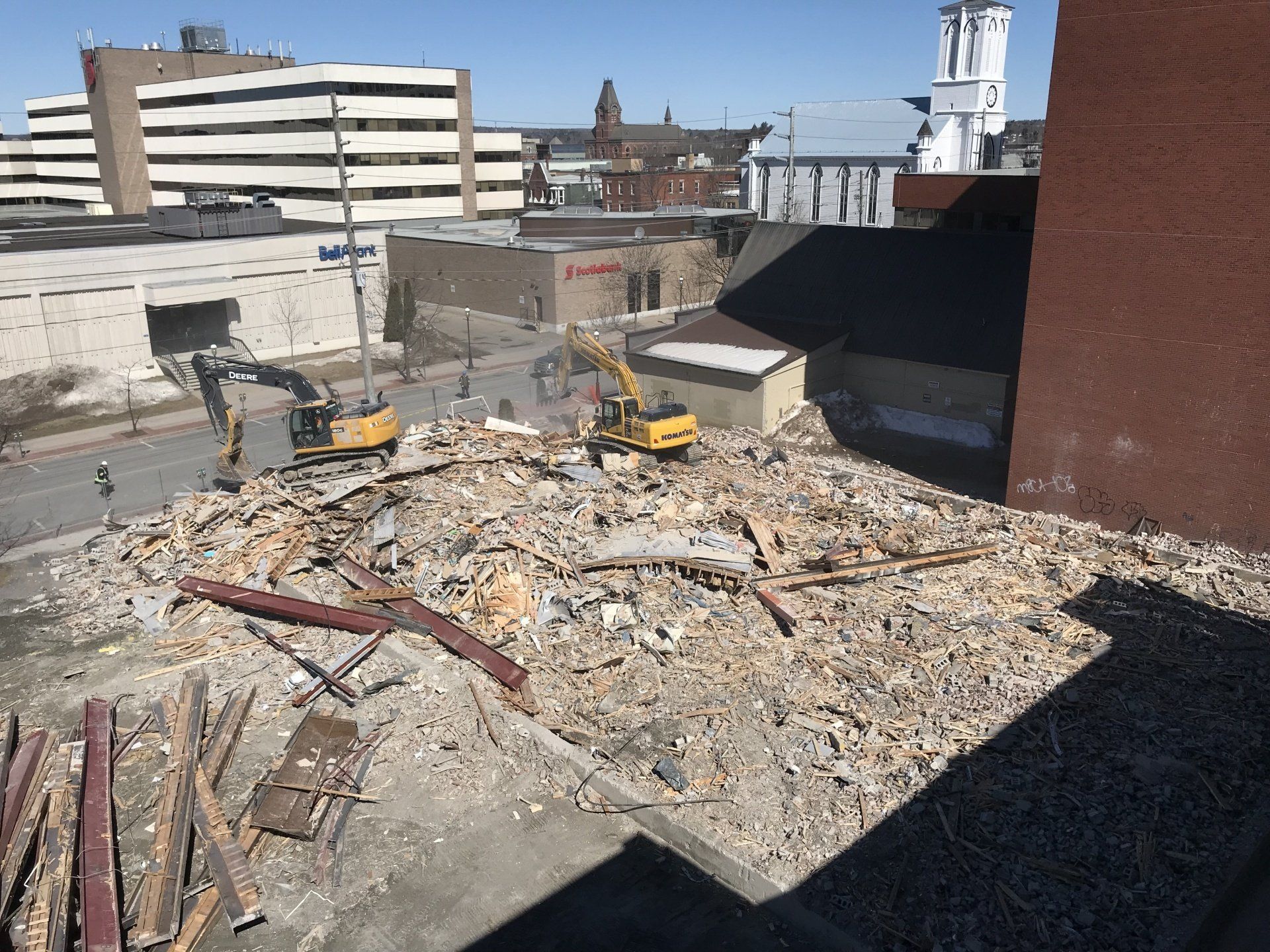 A construction site with a lot of rubble and a building in the background