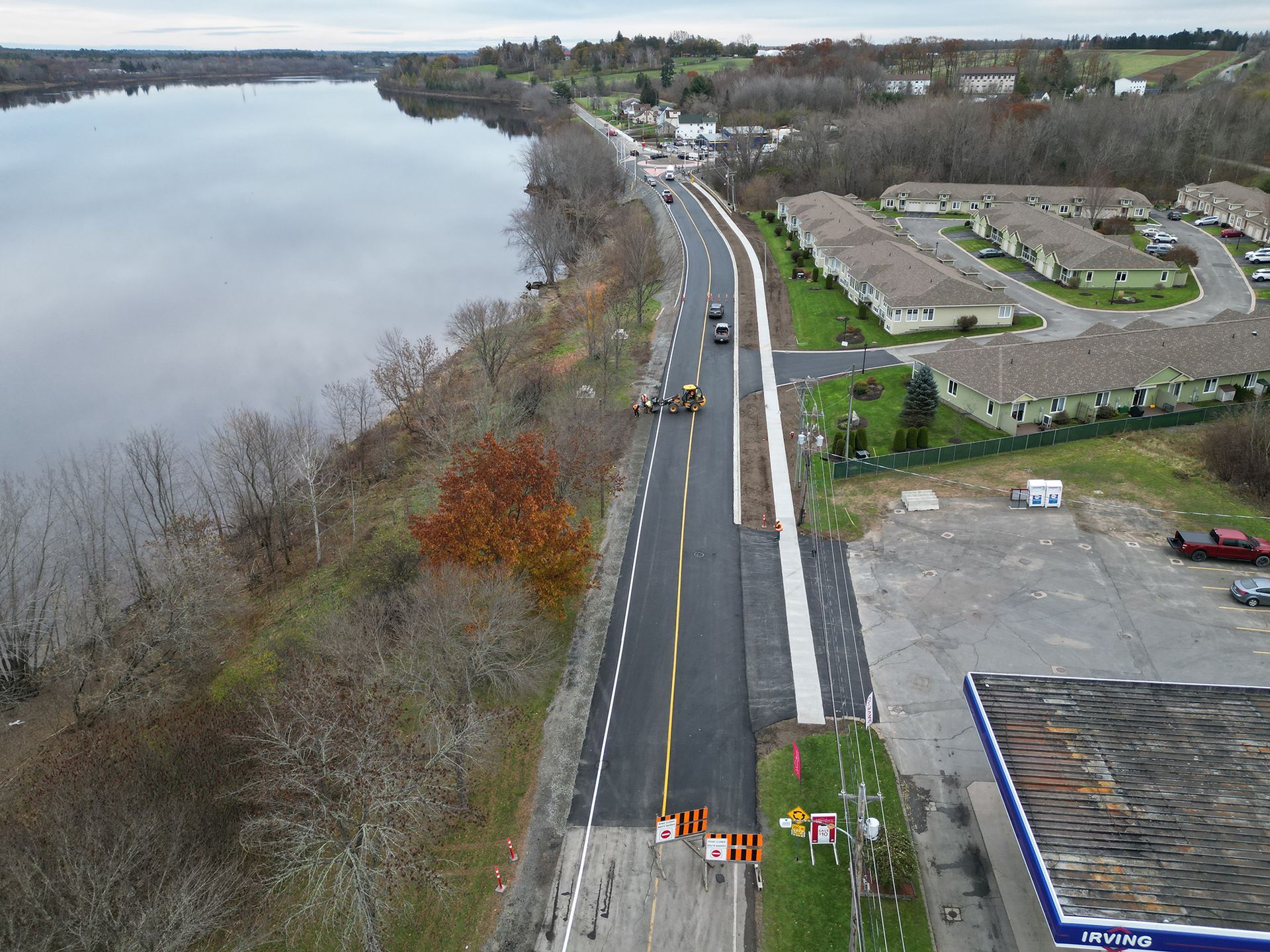 An aerial view of a road next to a body of water