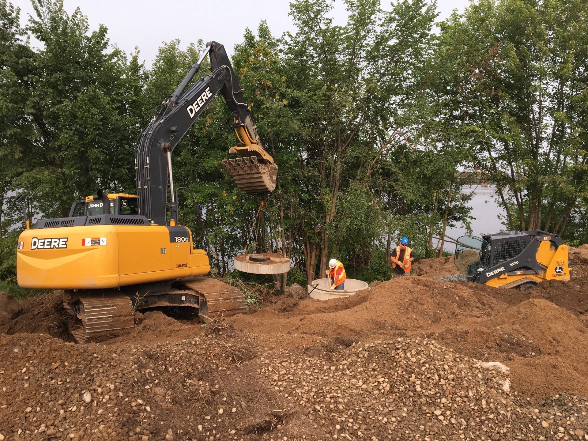 A yellow excavator is digging a hole in a pile of dirt.