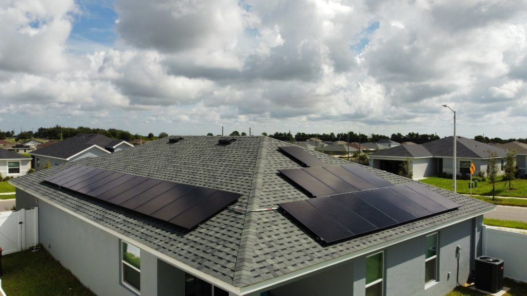 An aerial view of a house with solar panels on the roof.