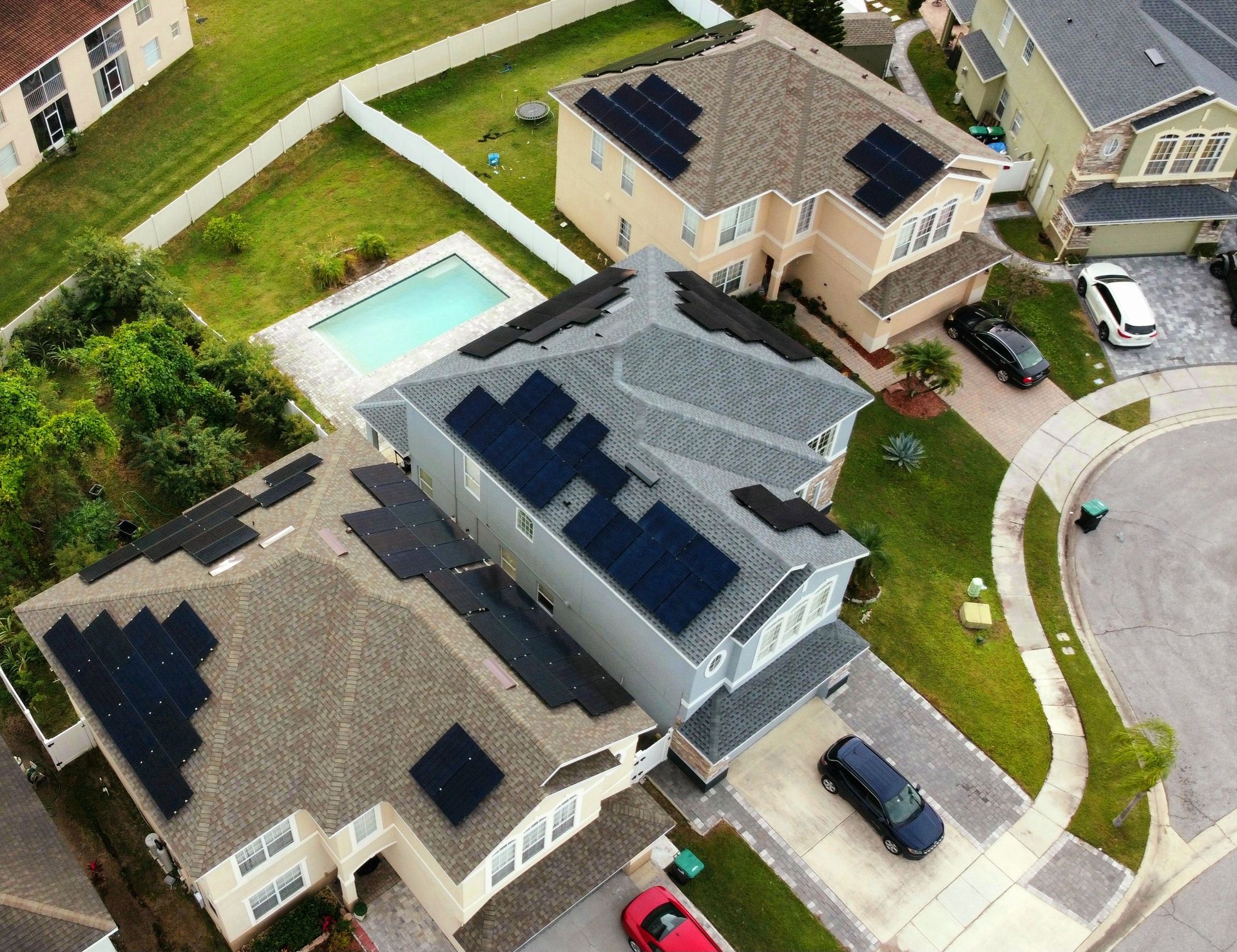 An aerial view of a residential neighborhood with solar panels on the roofs of houses.