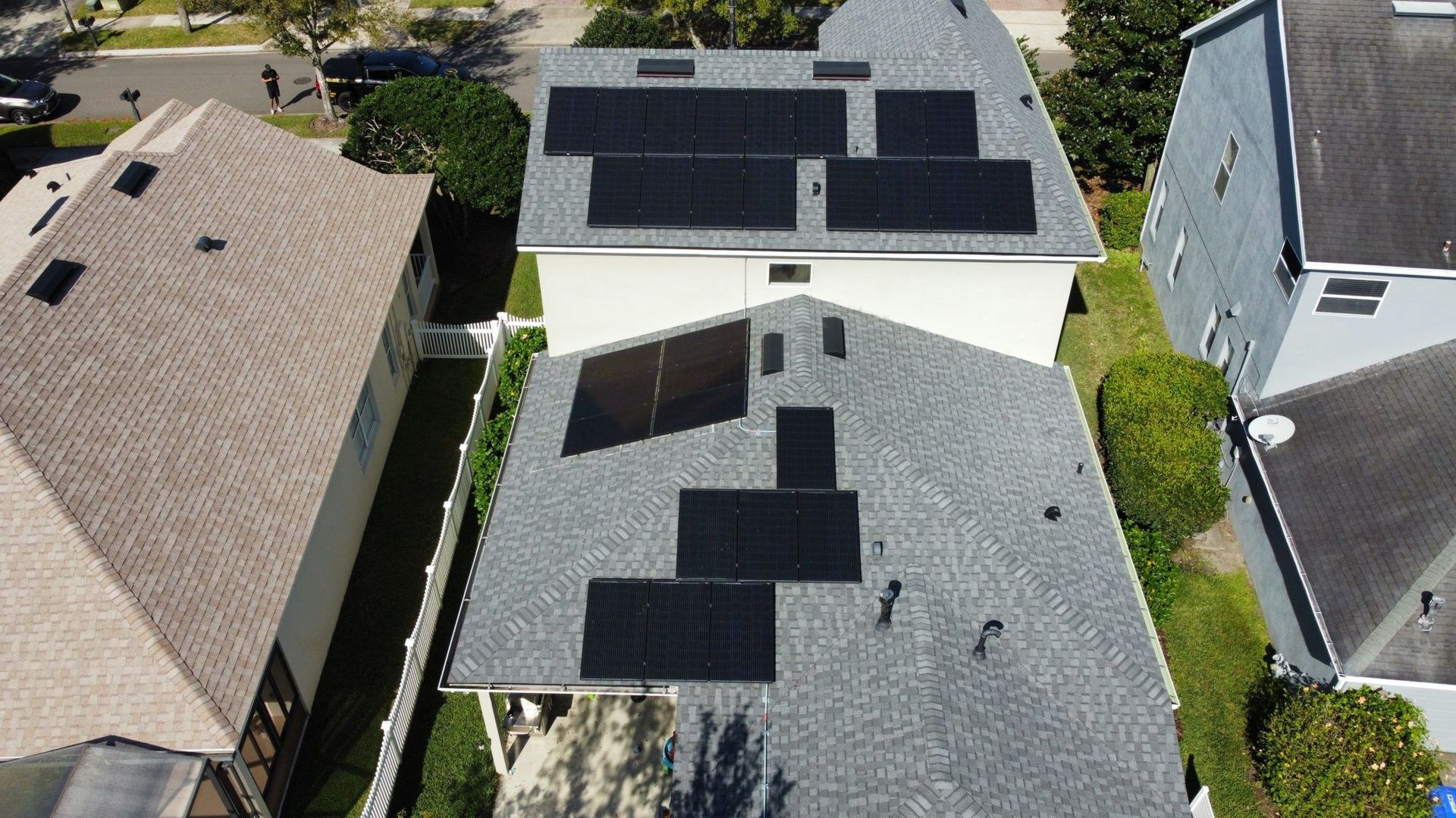 An aerial view of a house with solar panels on the roof.
