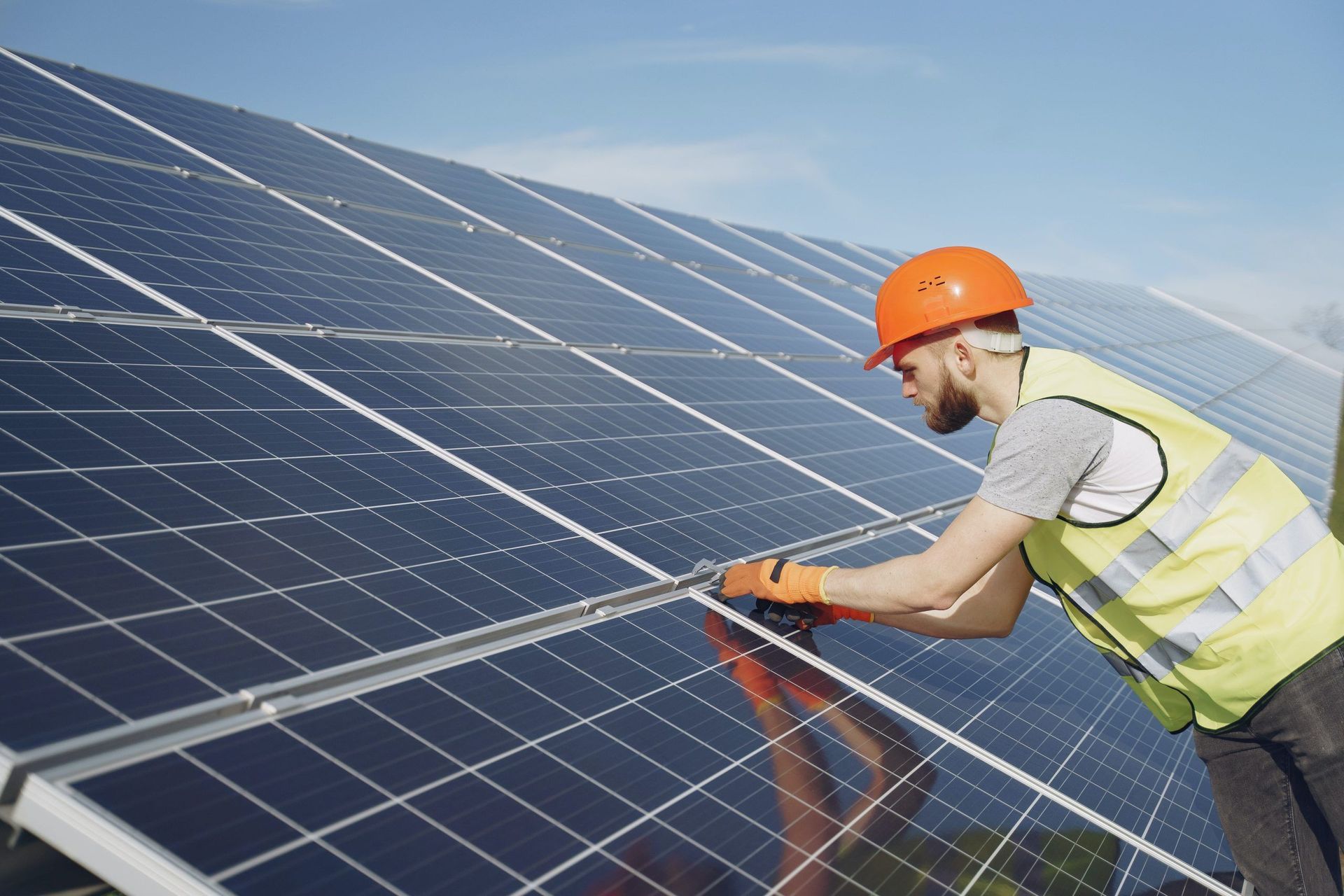 A man is installing solar panels on a roof.