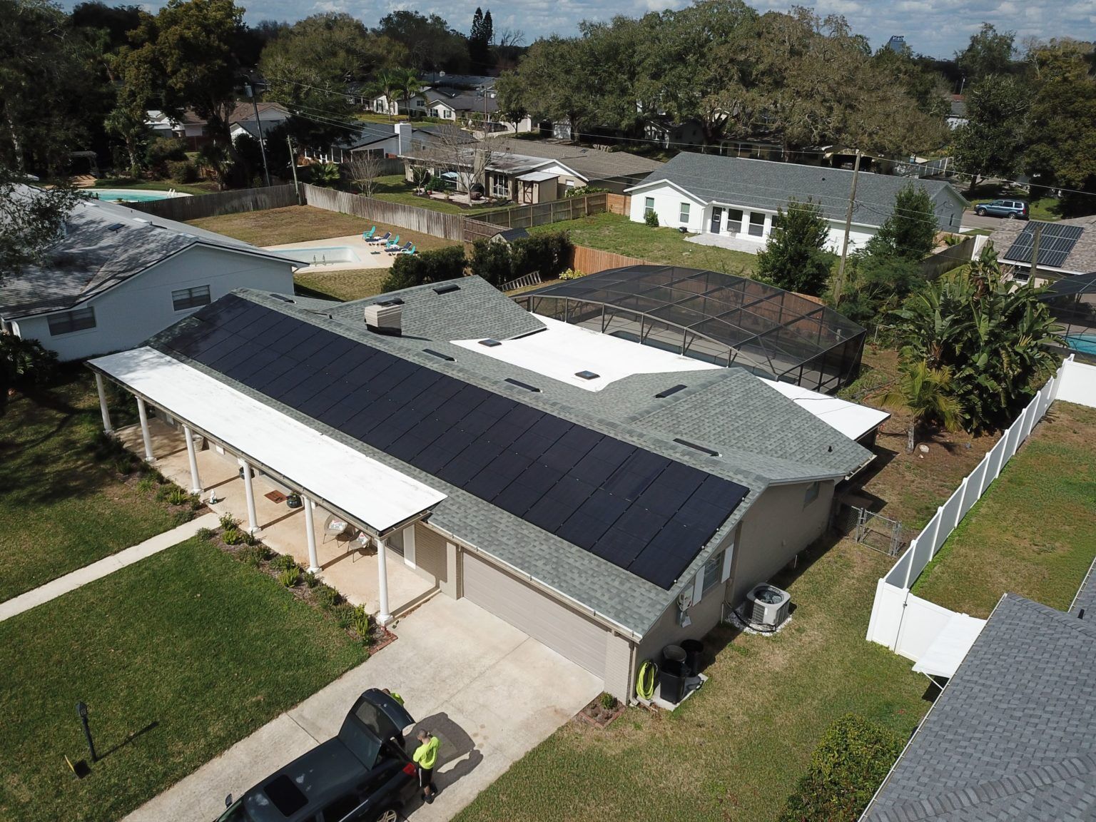 An aerial view of a house with solar panels on the roof.