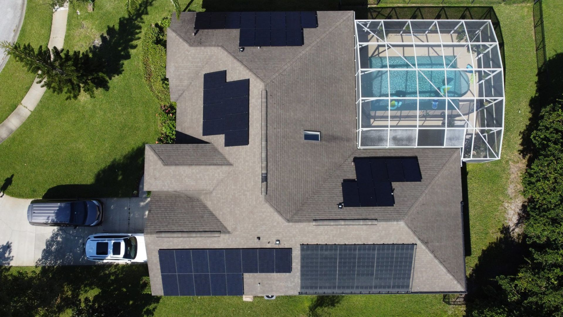 An aerial view of a house with solar panels on the roof.