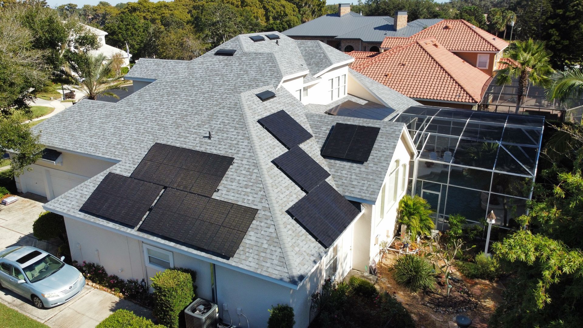 An aerial view of a house with solar panels on the roof.