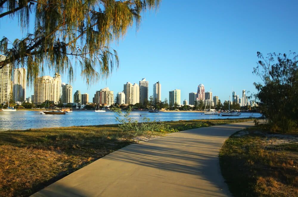 A Path Leading to A Body of Water with A City in The Background — Goldspark GC Electrical in Nerang, QLD