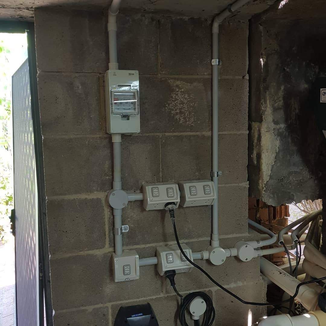 A Brick Wall with A Bunch of Wires Coming Out Of It — Goldspark GC Electrical in Burleigh Waters, QLD