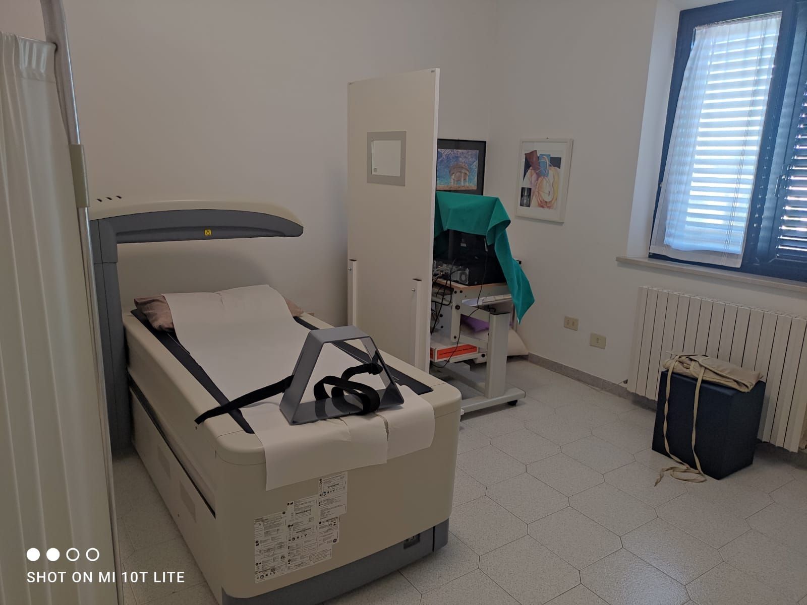 Sala visite mediche con letto per pazienti e attrezzature.