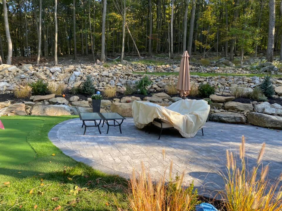 There is a patio with a table and chairs and an umbrella.