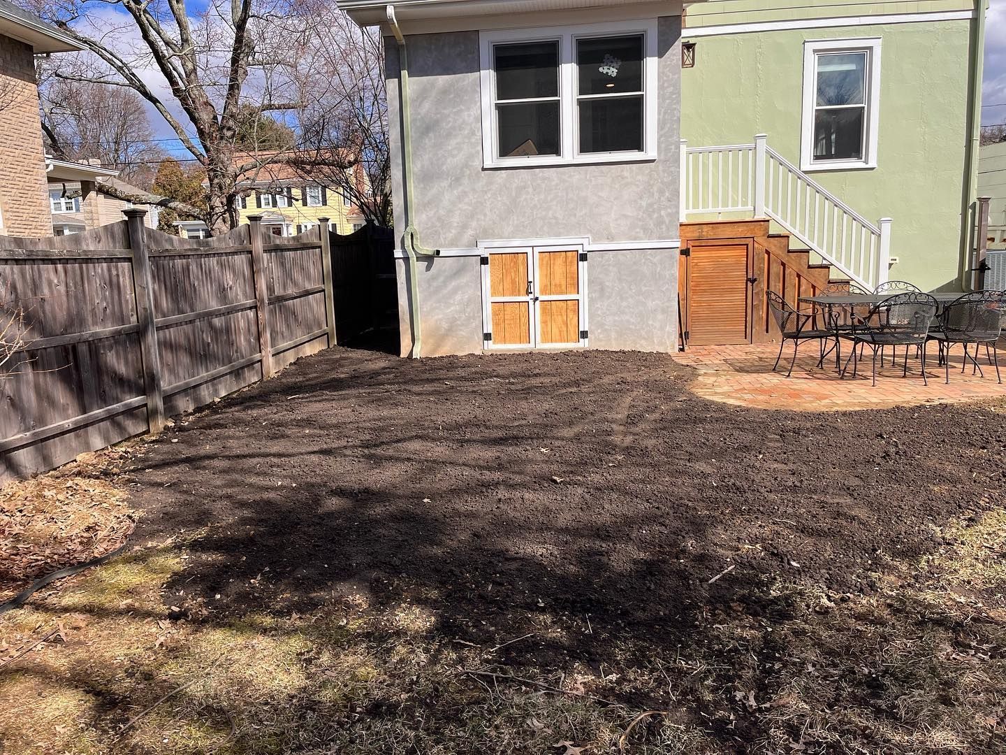 The backyard of a house with a fence and stairs.