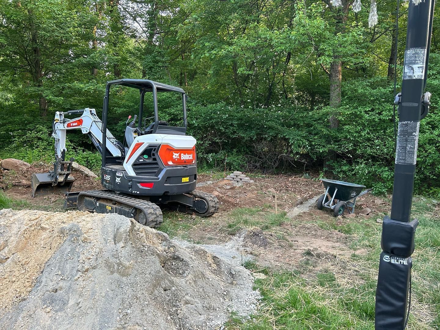 A small excavator is sitting on top of a pile of dirt.