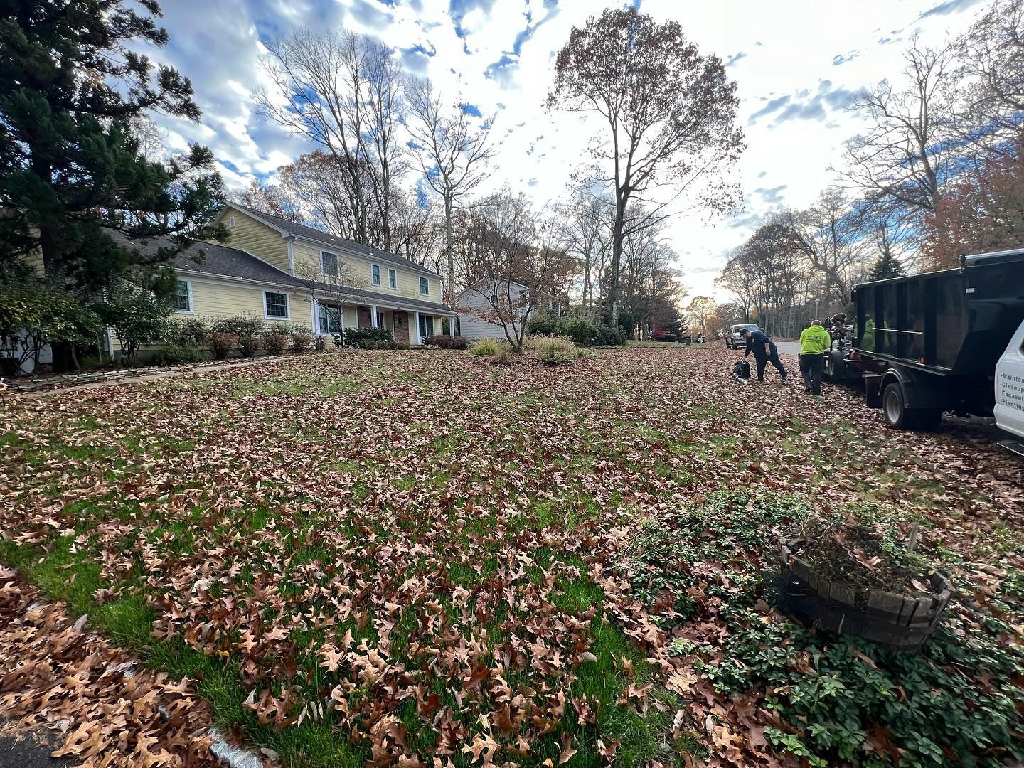 A large pile of leaves is sitting in front of a house.