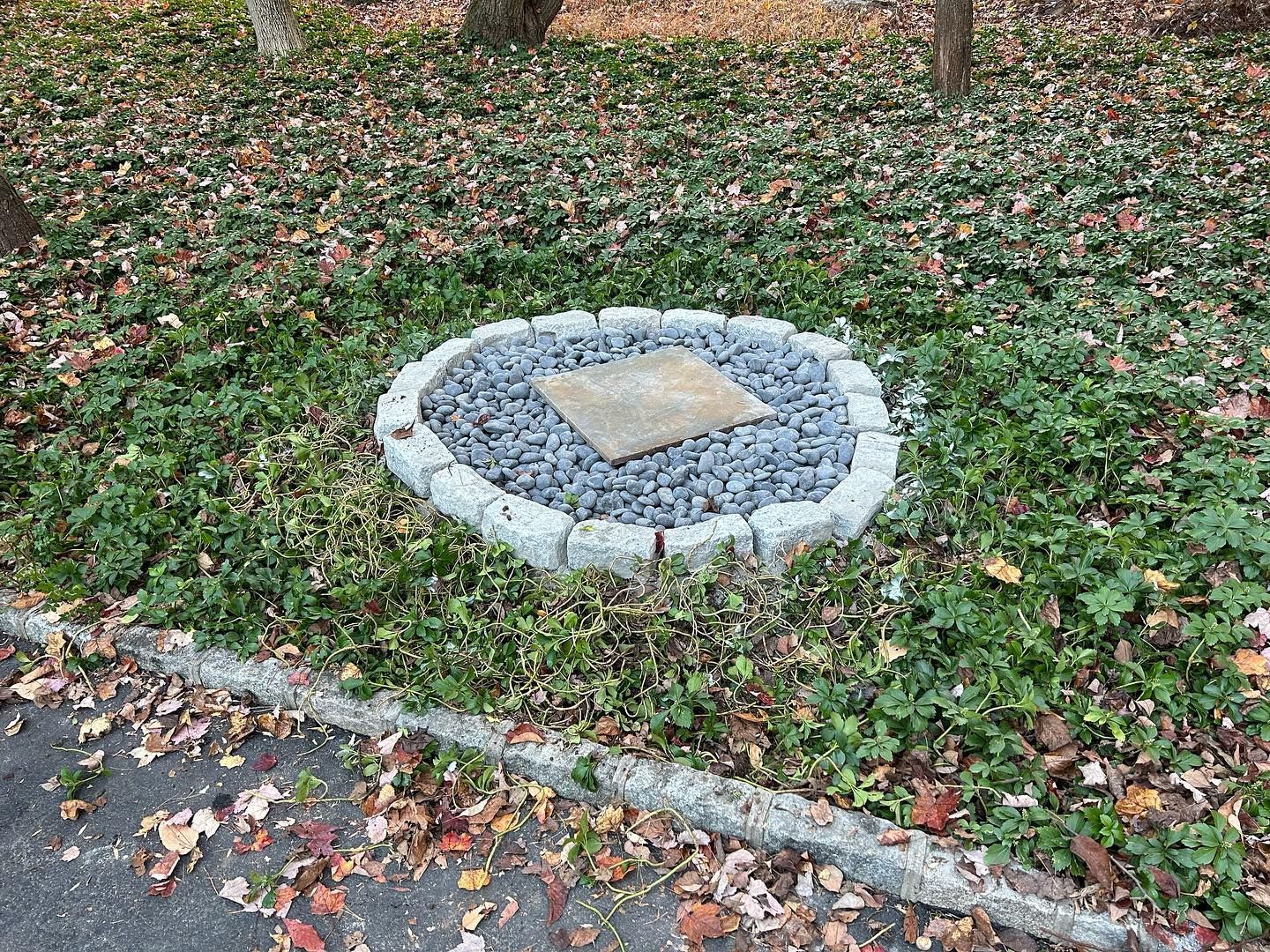 There is a stone in the middle of a circle of gravel.