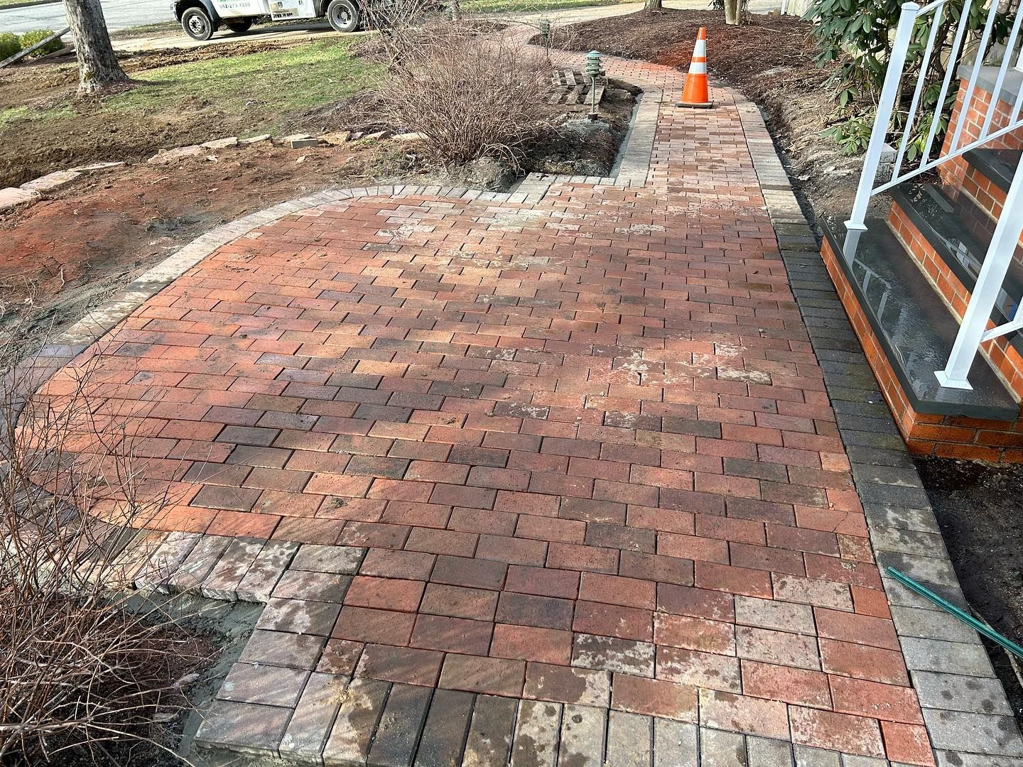 A brick walkway with stairs leading up to a house.