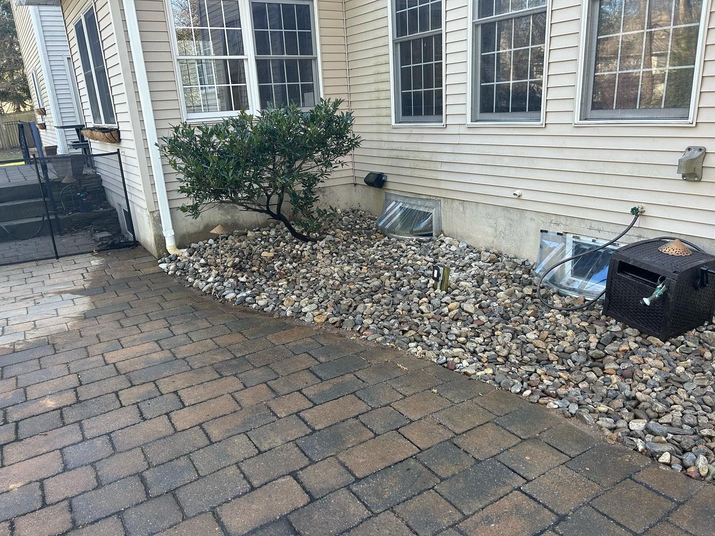A brick walkway leading to a house with a mailbox on the side of it.