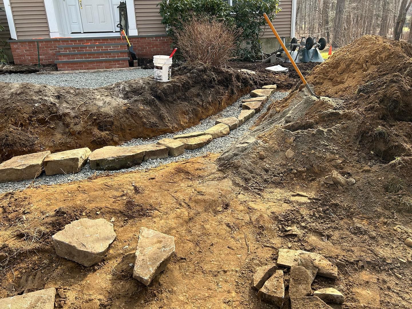 A dirt path is being built in front of a house.