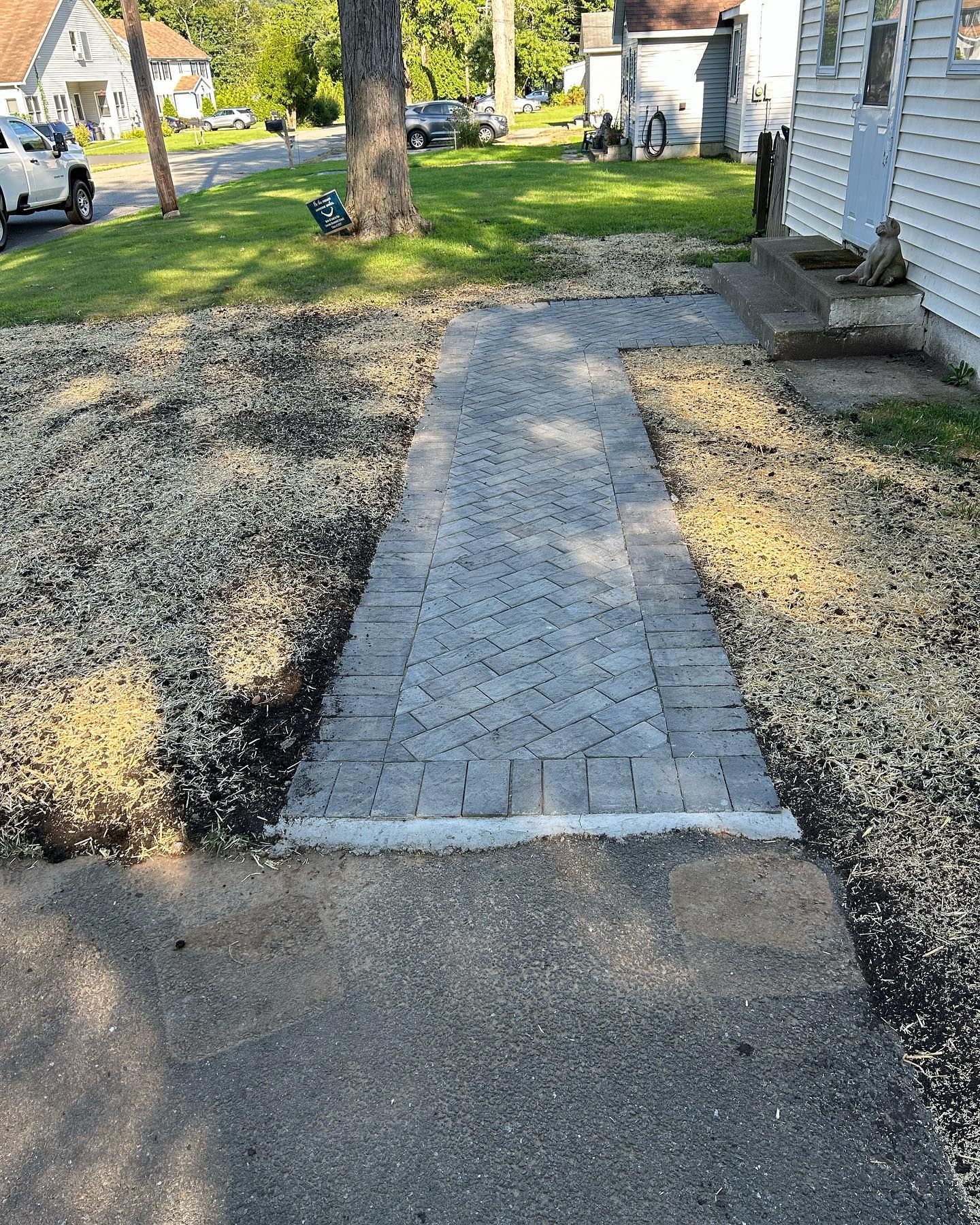 A brick walkway is being built in front of a house.