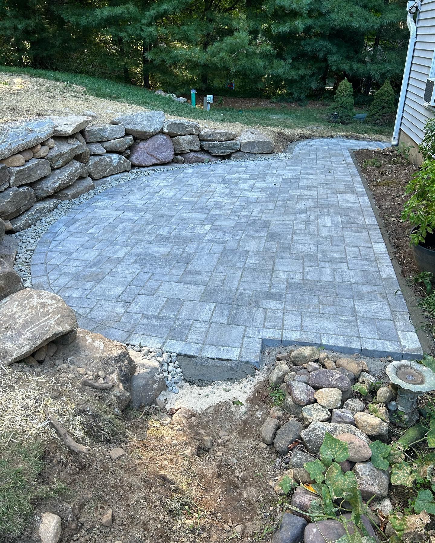 A patio is being built in the backyard of a house.