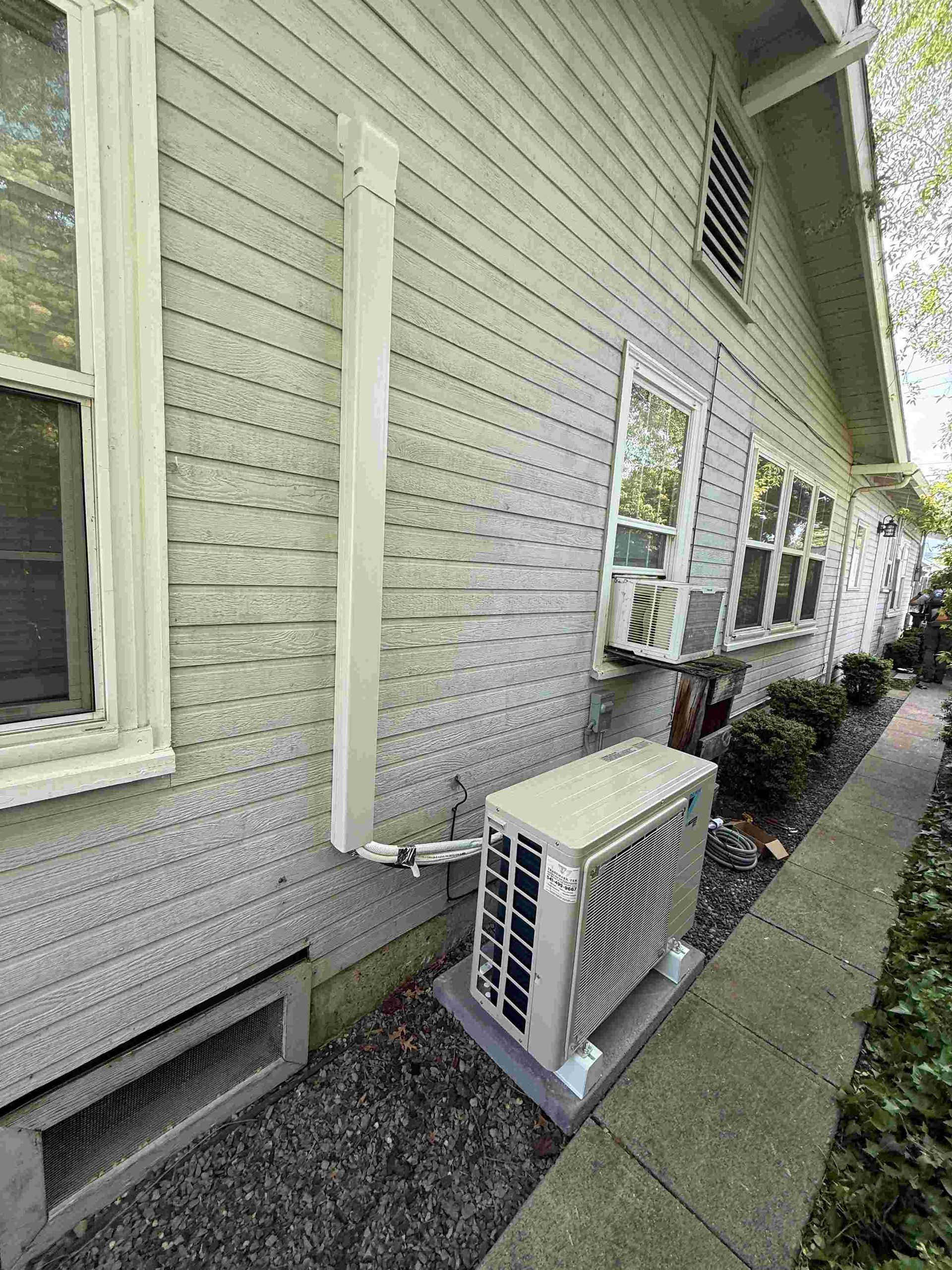 Exterior of building with an air conditioning unit; side view.