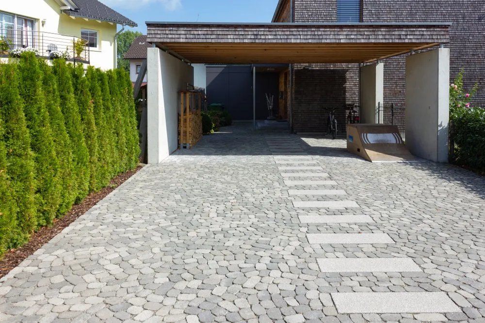 A Brick Driveway Leading to A Carport with A Wooden Roof — Manning Valley Patios in Cundletown, NSW