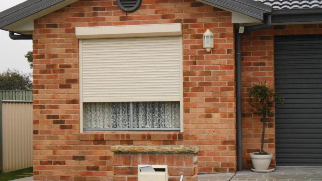 A Brick House with A Window with A Roller Shutter on It — Manning Valley Patios in Cundletown, NSW
