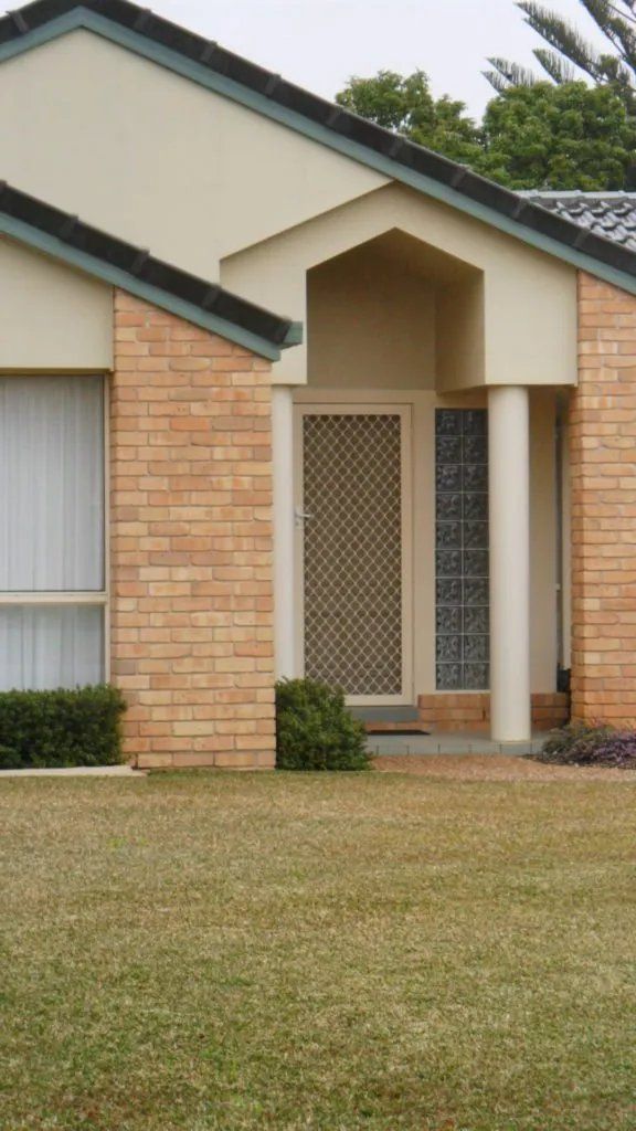 A Brick House with A White Roof and A Screen Door — Manning Valley Patios in Cundletown, NSW