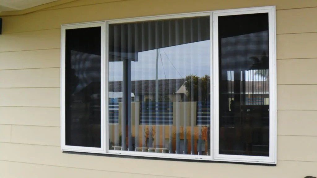 A Window with Vertical Blinds Is on The Side of A House — Manning Valley Patios in Cundletown, NSW