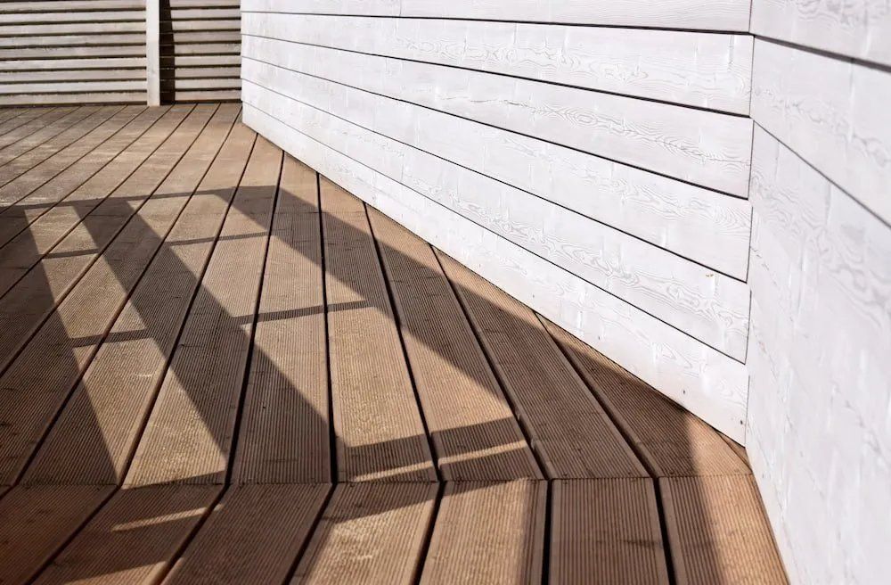A Wooden Deck with A White Wall Behind It —Manning Valley Patios in Old Bar, NSW