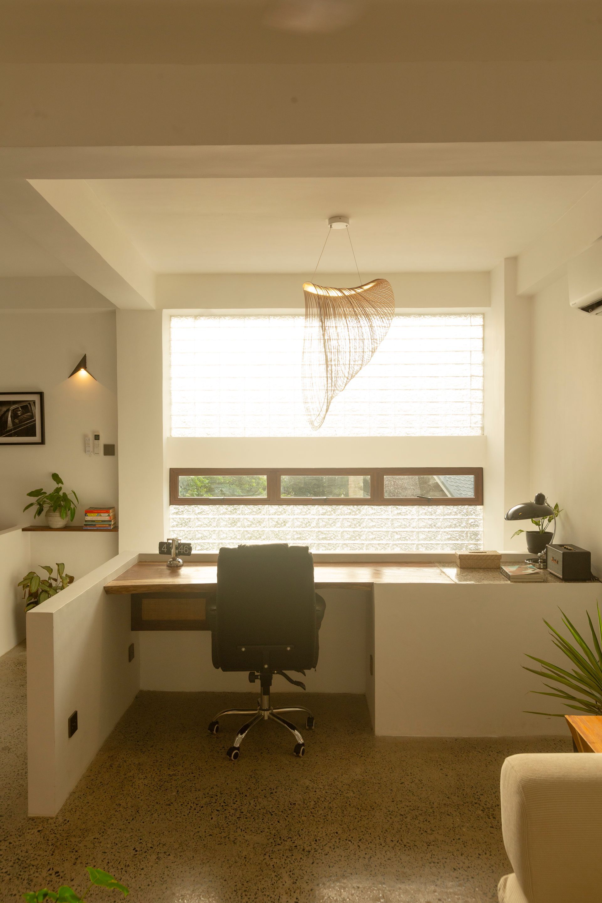 Bright office space with desk, chair, and window overlooking greenery.