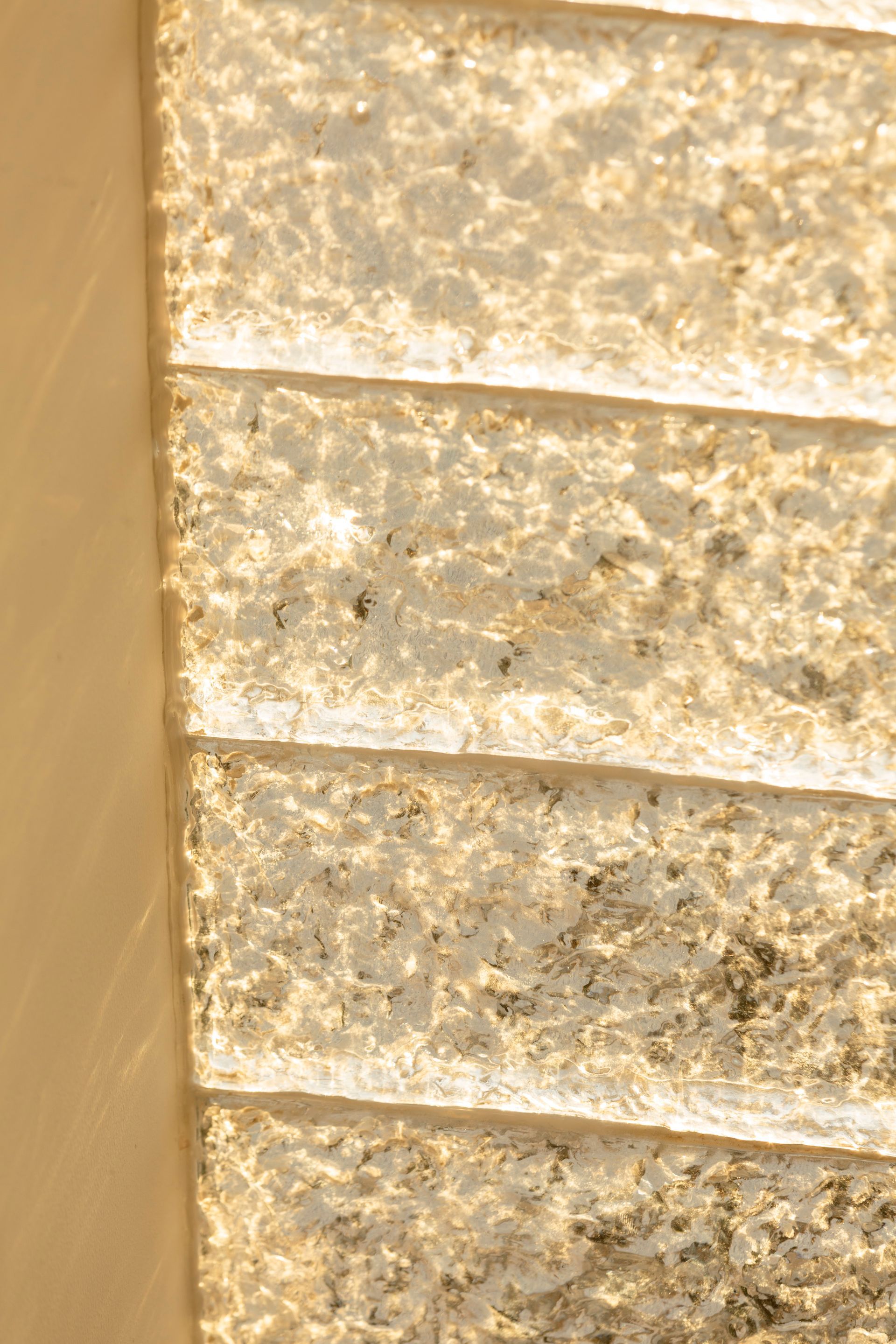 Close-up of a series of textured, rectangular panels, layered with light and shadow.