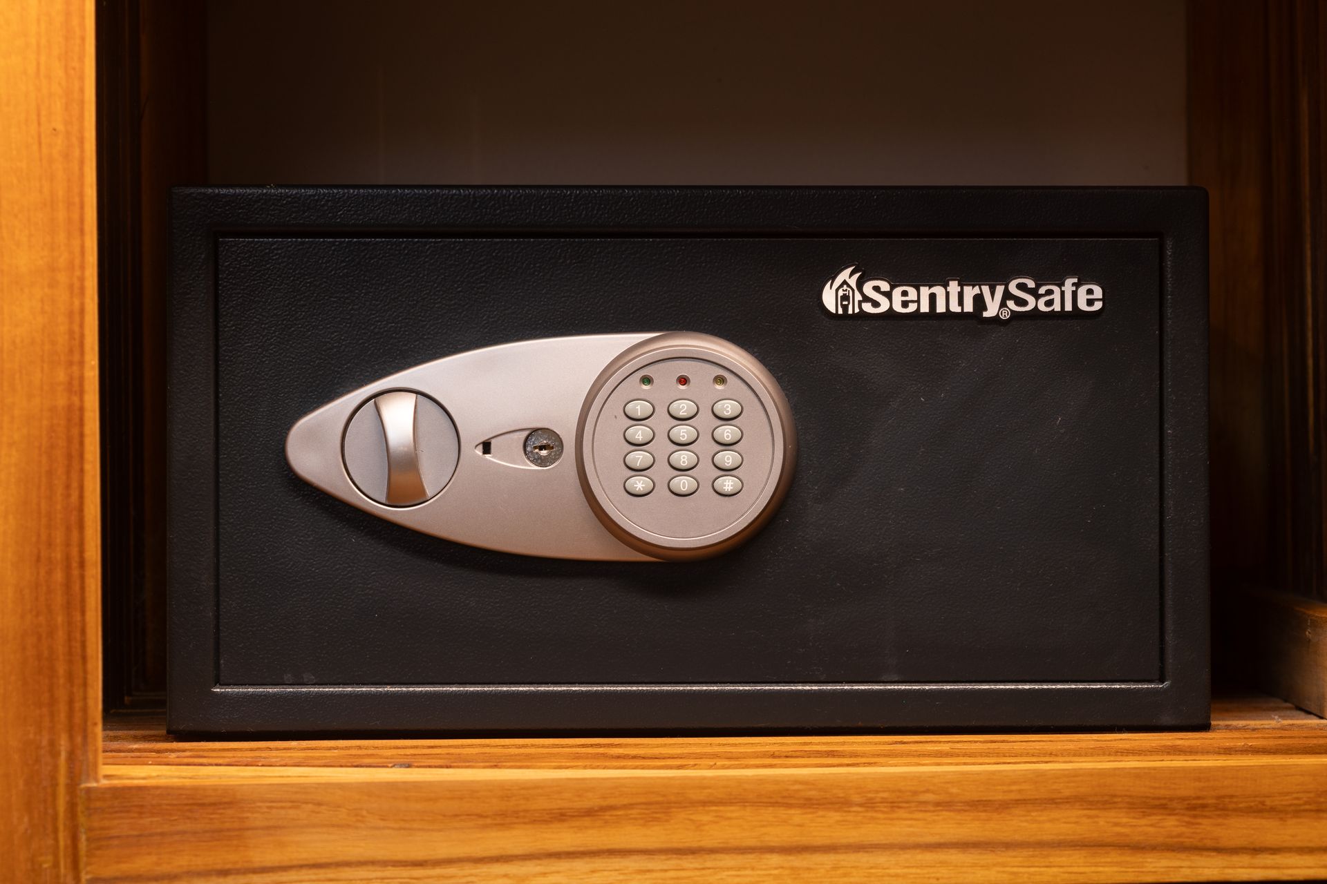 Black SentrySafe digital safe inside a wooden shelf.