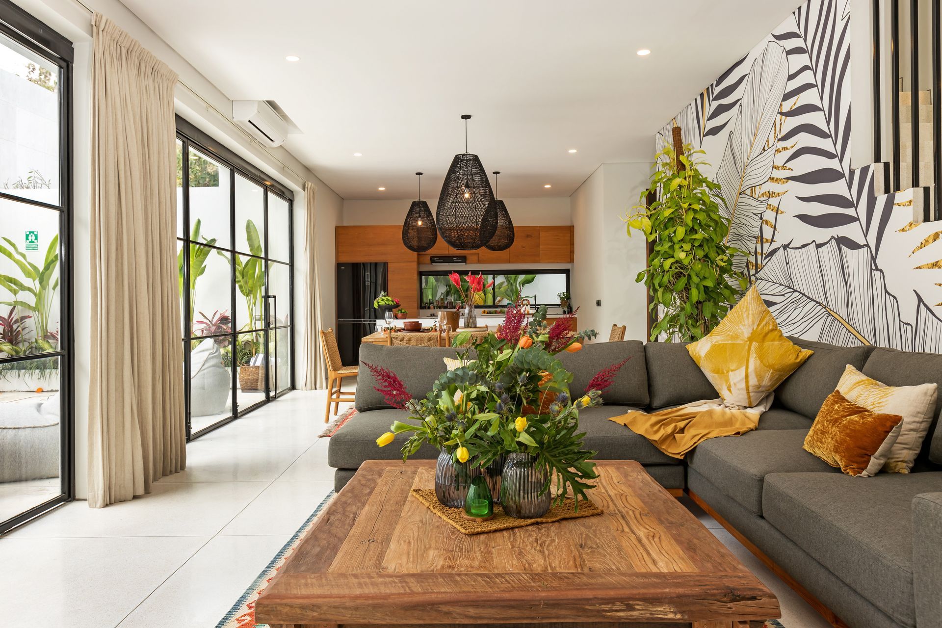 Living room with gray sectional, wood coffee table, and open to a dining area.