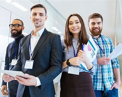 A group of people are standing next to each other in an office.