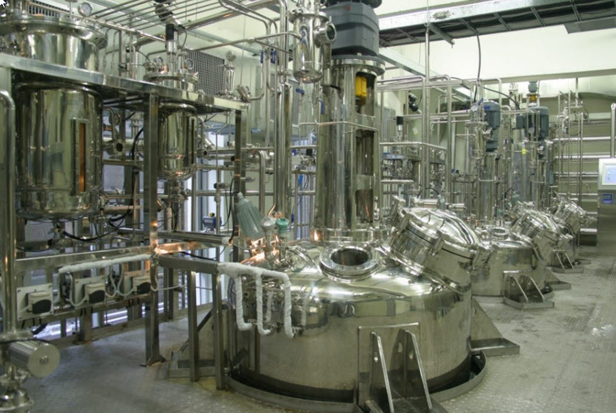 A large room filled with lots of stainless-steel bioreactors, an image for batch process automation