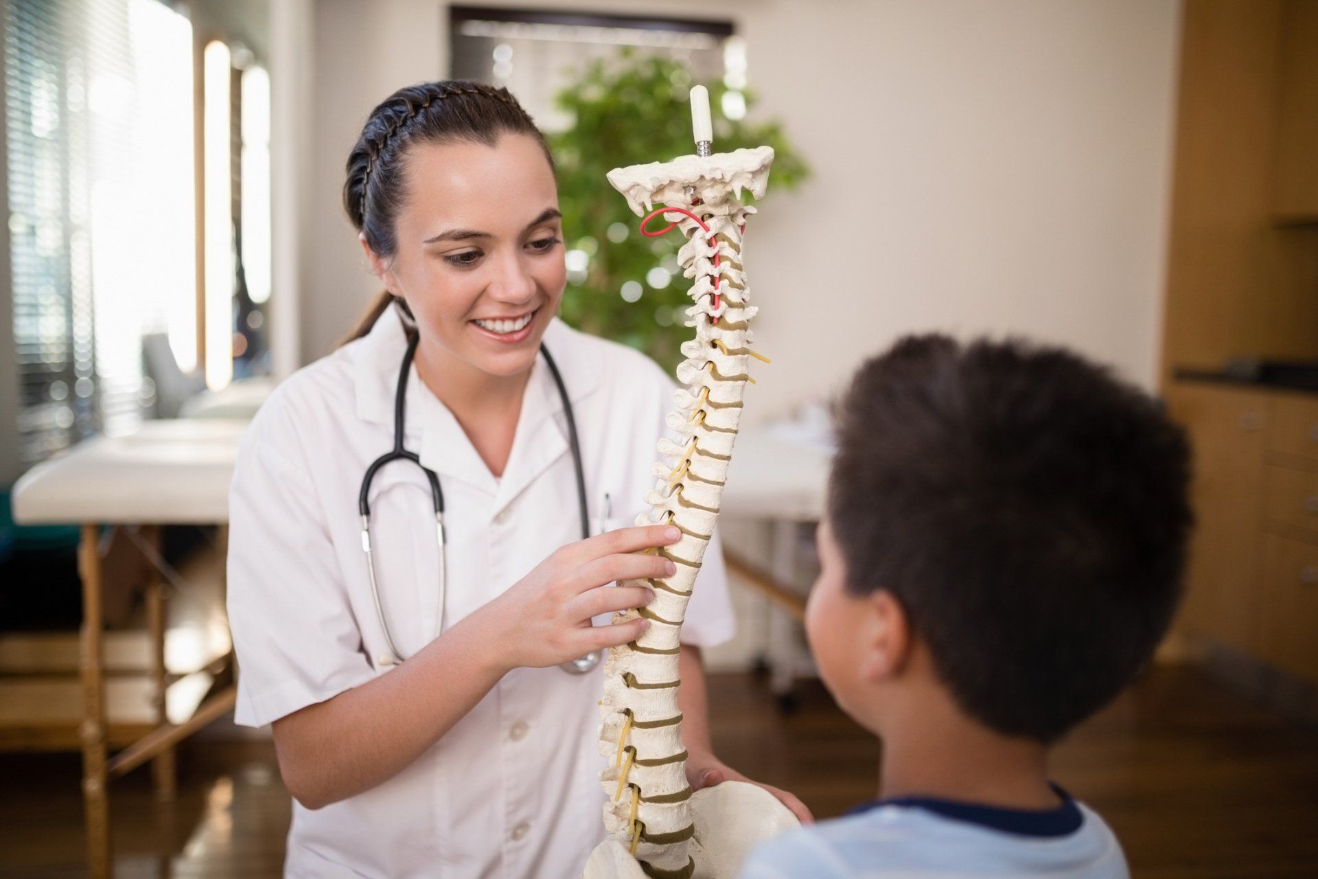 Chiropractor and child holding a spine model | Colorado Springs, CO | The Partridge Family Practice