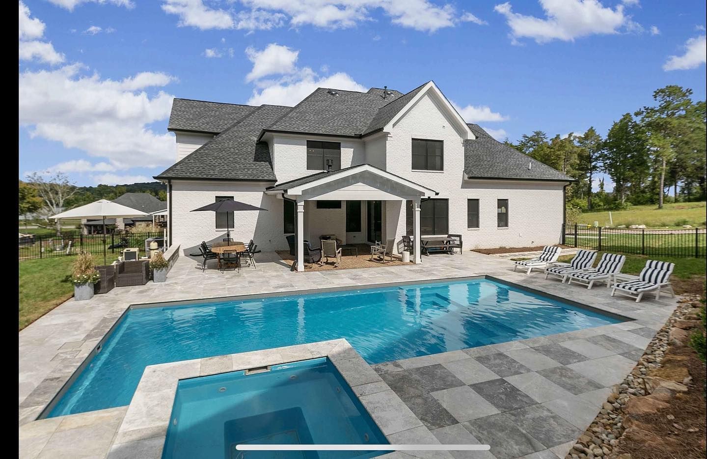 A large white house with a large swimming pool in front of it