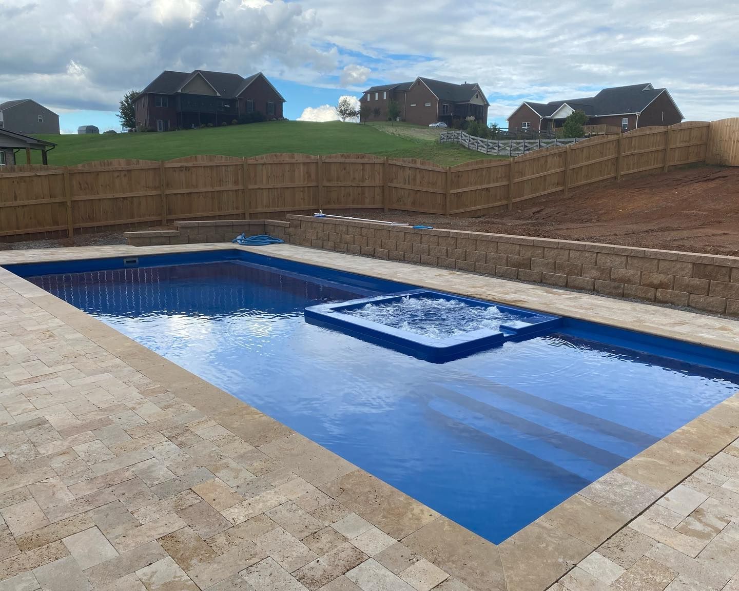 A large swimming pool with a wooden fence surrounding it