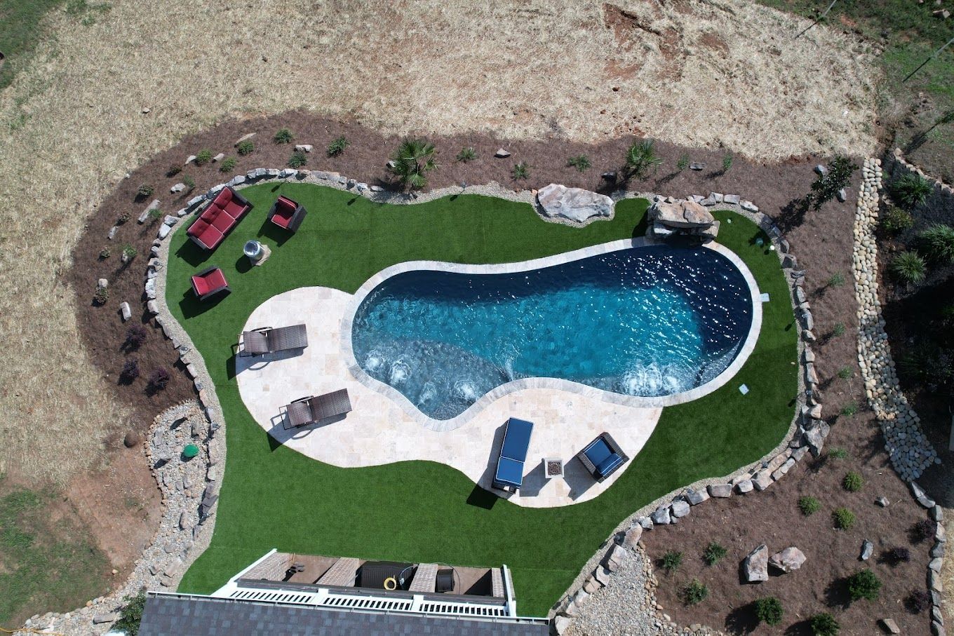 An aerial view of a large swimming pool surrounded by grass.