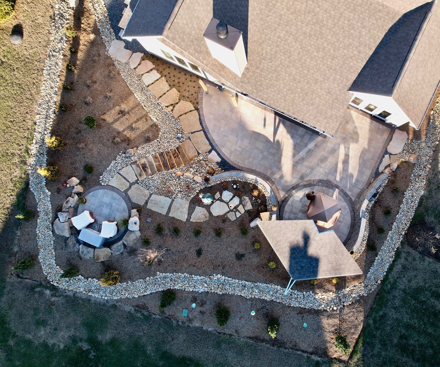 An aerial view of a house with a patio and a fire pit