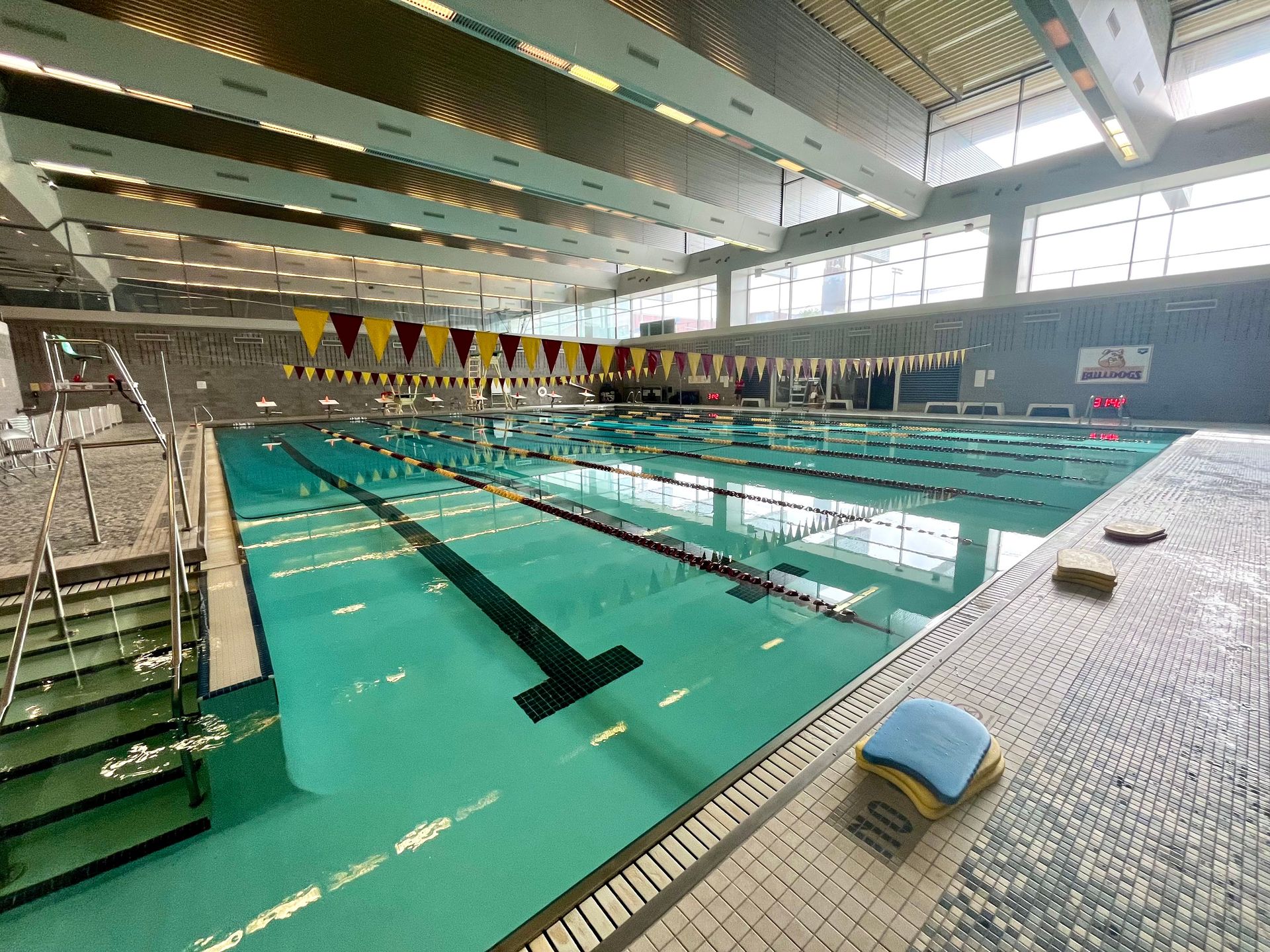 Indoor swimming pool with lanes, starting blocks, and flags.