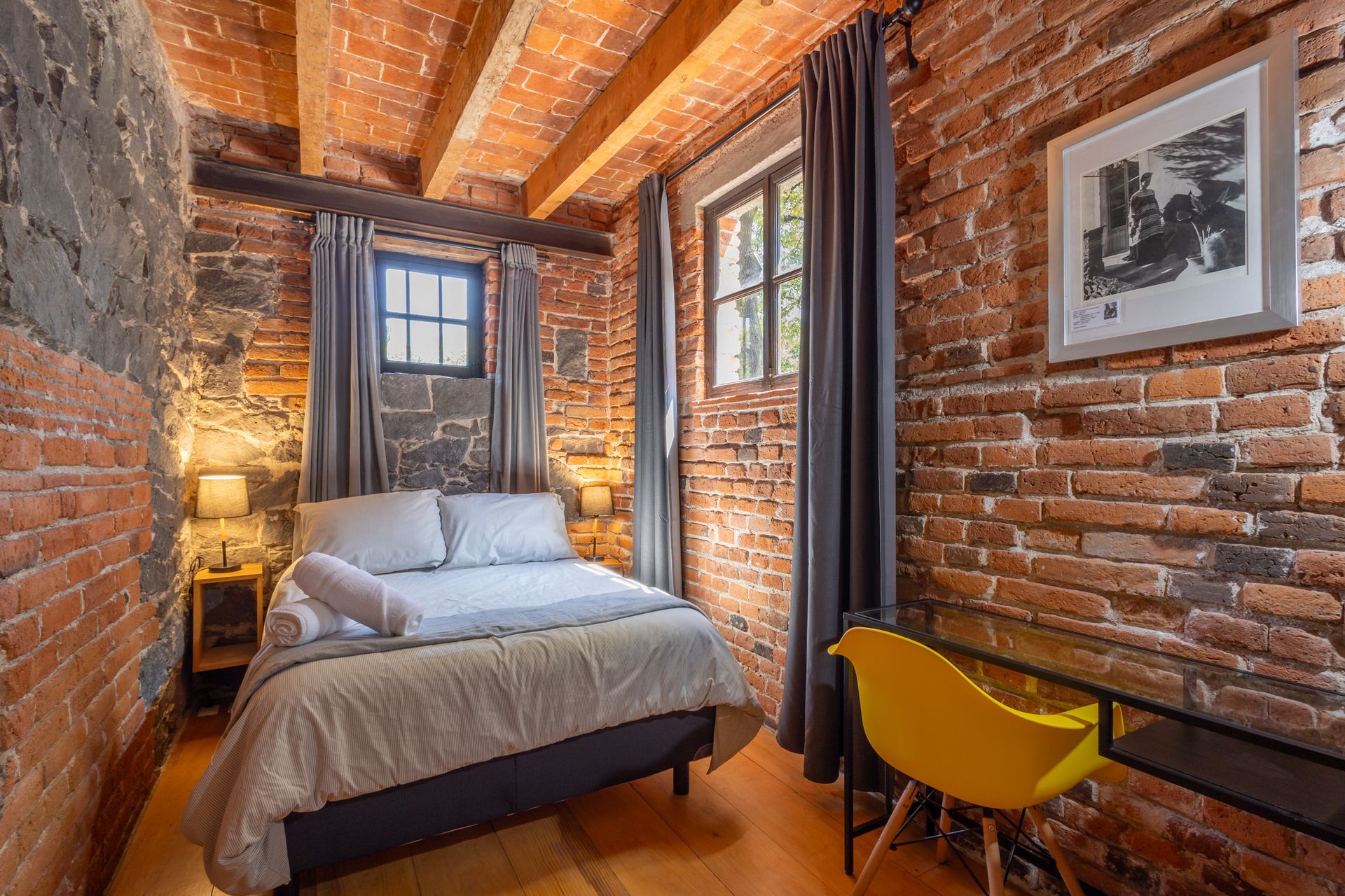 Un dormitorio con una cama y una pared de ladrillos.