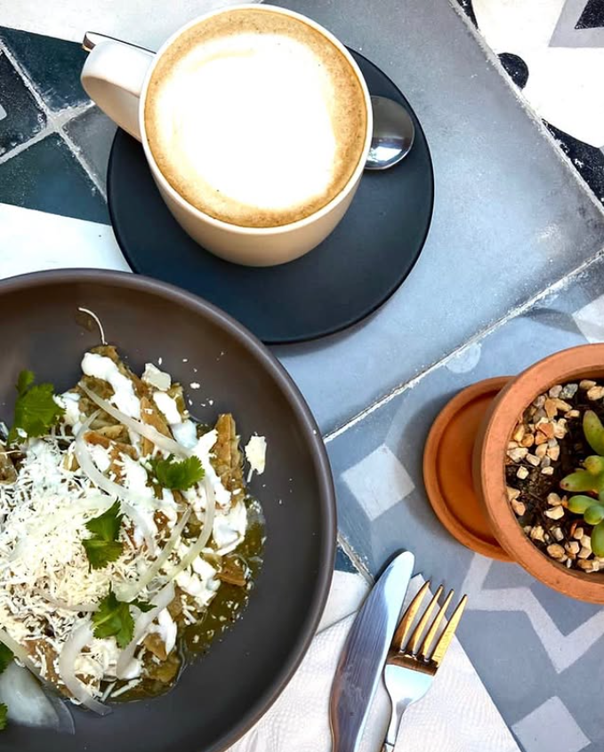 Un plato de comida y una taza de café sobre una mesa.